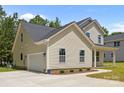 View of the side of the home featuring a 2-car garage and nice landscaping at 130 Aurora Blvd, Matthews, NC 28105