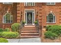 Welcoming brick stairs leading to the front door, framed by elegant landscaping and traditional architectural details at 1310 Weddington Hills Dr, Matthews, NC 28104