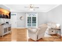 Bright living room featuring hardwood floors, a ceiling fan, a large window, and comfortable seating at 132 Witherspoon Ln, Statesville, NC 28677