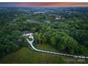 A sprawling estate nestled in a forest with a long driveway leading to the grand residence at 15037 June Washam Rd, Davidson, NC 28036