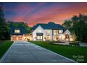 Beautiful luxury home with a three-car garage and a manicured front lawn with landscaped beds at 15037 June Washam Rd, Davidson, NC 28036