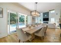 Elegant dining room with a modern chandelier, hardwood floors, and access to the pool area at 2121 Laburnum Ave, Charlotte, NC 28205
