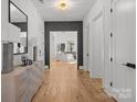Bright entryway features hardwood floors, a modern light fixture, and a glimpse into the living room at 2121 Laburnum Ave, Charlotte, NC 28205