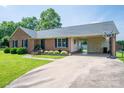 Well-maintained brick home featuring a convenient carport, basketball hoop, and beautifully landscaped front yard at 233 Reliance Rd, Kings Mountain, NC 28086