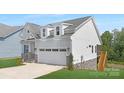 This is a view of the rear, featuring light blue siding, stone accents, and a wooden staircase at 24578 Blue Heron Cir # 407, Lancaster, SC 29720