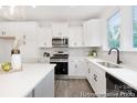 Bright kitchen features white cabinets, stainless steel appliances, and a large window at 24578 Blue Heron Cir # 407, Lancaster, SC 29720
