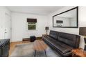 Cozy living room with a leather sofa, large mirror, and stylish rug at 2607 Vail Ave, Charlotte, NC 28207