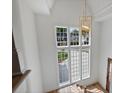 Bright foyer featuring a large window and a stylish chandelier, complemented by hardwood flooring at 2921 Windsor Ave, Charlotte, NC 28209