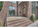 Inviting front entrance with stone steps, a wooden door with glass, and attractive brick and stone facade at 2921 Windsor Ave, Charlotte, NC 28209