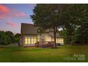 View of the house featuring a wooden deck and a spacious yard with lush trees at 3213 Strawberry Rd, Matthews, NC 28104