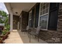 Inviting front porch with stone accents and a comfortable seating area; a perfect outdoor retreat at 3351 Streamside Dr, Davidson, NC 28036
