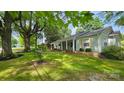 Well-maintained home featuring a lush front lawn and inviting covered porch, framed by mature trees at 415 S Central Ave, Locust, NC 28097