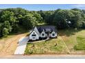 Newly constructed white farmhouse with black trim on a large lot with verdant landscaping at 5015 Lancaster Hwy, Monroe, NC 28112
