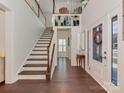 Bright foyer featuring a wooden staircase and elegant hardwood flooring and white door at 5020 Forest Hills Pl, Fort Mill, SC 29707
