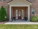 Charming brick home featuring a welcoming front entrance with a decorative wreath and lovely potted plants at 5020 Forest Hills Pl, Fort Mill, SC 29707