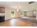 Inviting living space featuring a combination of wood flooring and carpet, bright windows, and a kitchen at 828 Carver St # 17-19, Shelby, NC 28152
