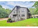 Beautiful home with a stone facade, backyard with a black fence, and a wooden deck at 9423 Man O War Rd, Fort Mill, SC 29707