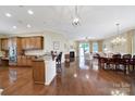 Open-concept living space featuring hardwood floors, a modern kitchen, cozy breakfast nook, and access to the outdoor patio at 964 Knob Creek Ln, Fort Mill, SC 29708