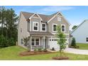 Attractive two-story home with gray siding, a manicured lawn, and an attached two-car garage at 9858 Jack Nicklaus Dr # 897, Lancaster, SC 29720