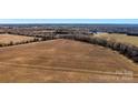 Wide aerial shot of land with a road, showing a mix of fields, woods, and the property's potential at 0000 Milling Rd, Rock Hill, SC 29730