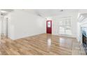 Bright living room features wood floors, a fireplace, and a red front door at 131 Canopy Ct, Mooresville, NC 28115
