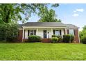 Charming home featuring a well-manicured lawn and front porch, set against a clear, blue sky at 1512 Anthony Dr, Gastonia, NC 28052