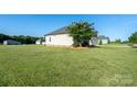 Well-maintained single-story home surrounded by a large, green lawn at 17438 Purser Dr, Locust, NC 28097