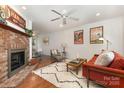 Bright living room with a brick fireplace, hardwood floors and comfortable seating at 1912 Baxter St, Charlotte, NC 28204