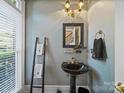 Stylish powder room featuring a pedestal sink, unique mirror, and elegant lighting at 2769 Independence Way, Gastonia, NC 28056