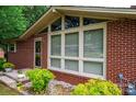 Close-up of the home's brick facade, large windows, and neatly landscaped flower beds at 2836 20Th Street Ne Ln, Hickory, NC 28601