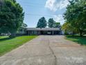 Spacious driveway leading to a charming home with lush landscaping and a welcoming entrance at 3509 Flint Dr, Statesville, NC 28677