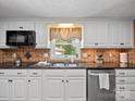 Charming kitchen with white cabinetry, dark countertops, and a stainless steel dishwasher at 3509 Flint Dr, Statesville, NC 28677