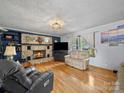 Cozy living room featuring a stone fireplace, hardwood floors, and comfortable seating at 3509 Flint Dr, Statesville, NC 28677