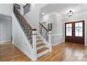 Elegant entryway featuring hardwood floors, staircase with wrought iron railings, and a beautiful front door at 3622 46Th Ne Ave, Hickory, NC 28601