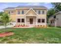 Charming two-story home featuring a brick and siding exterior, covered front porch, and well-manicured lawn at 4015 Randolph Rd, Charlotte, NC 28211