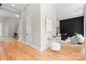 Bright hallway featuring hardwood floors, white trim, and a glimpse into a stylishly decorated living area at 4015 Randolph Rd, Charlotte, NC 28211