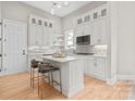 Modern kitchen features white cabinets, subway tile backsplash, an island with seating and pendant lighting at 4015 Randolph Rd, Charlotte, NC 28211