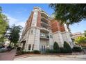 Corner view showcasing the building's brick and concrete exterior, multiple balconies and nice landscape at 415 N Church St # 311, Charlotte, NC 28202