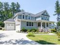Beautiful two-story home with a front porch, three-car garage, and well-manicured lawn at 4237 Island Fox Ln, Denver, NC 28037
