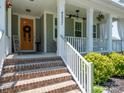 Inviting front porch with brick steps, white railings, and a decorative front door at 4237 Island Fox Ln, Denver, NC 28037