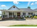 Welcoming front entrance with covered porch, brick steps, decorative sidelights, and meticulous landscaping around walkway at 441 Wildlife Club Ln, Taylorsville, NC 28681