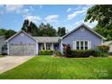 Charming one-story home with manicured lawn, beautiful landscaping and periwinkle blue siding at 5711 Lambrook Ct, Charlotte, NC 28269