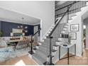 Bright foyer featuring a staircase with decorative black wrought iron railings and adjacent dining area at 7800 Conifer Cir, Indian Trail, NC 28079