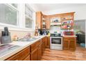 Bright kitchen with wooden cabinets, stainless steel range, white countertops, and vinyl wood-look flooring at 816 Fulton St, Albemarle, NC 28001