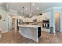 Bright, open kitchen featuring a large center island, modern appliances, and stylish pendant lighting at 11313 Limehurst Pl, Charlotte, NC 28278