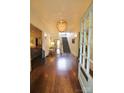 Elegant foyer with dark wood floors, a decorative chandelier, and a staircase leading to the second floor at 1137 Queens W Rd, Charlotte, NC 28207