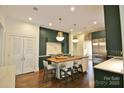 Modern kitchen with an island, stainless steel appliances, dark green cabinetry, and ample counter space at 1137 Queens W Rd, Charlotte, NC 28207