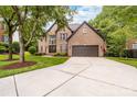 Charming two-story brick home featuring a long driveway and attached garage at 12002 Cobham Ct, Huntersville, NC 28078