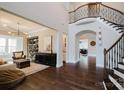 Grand foyer with hardwood floors, curved staircase, and sophisticated decor, showcasing an open floor plan at 15103 Cimarron Hills Ln, Charlotte, NC 28278