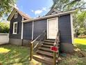 Exterior view of the home with a wooden staircase leading to a back door and fenced yard at 235 Jefferson E St, York, SC 29745